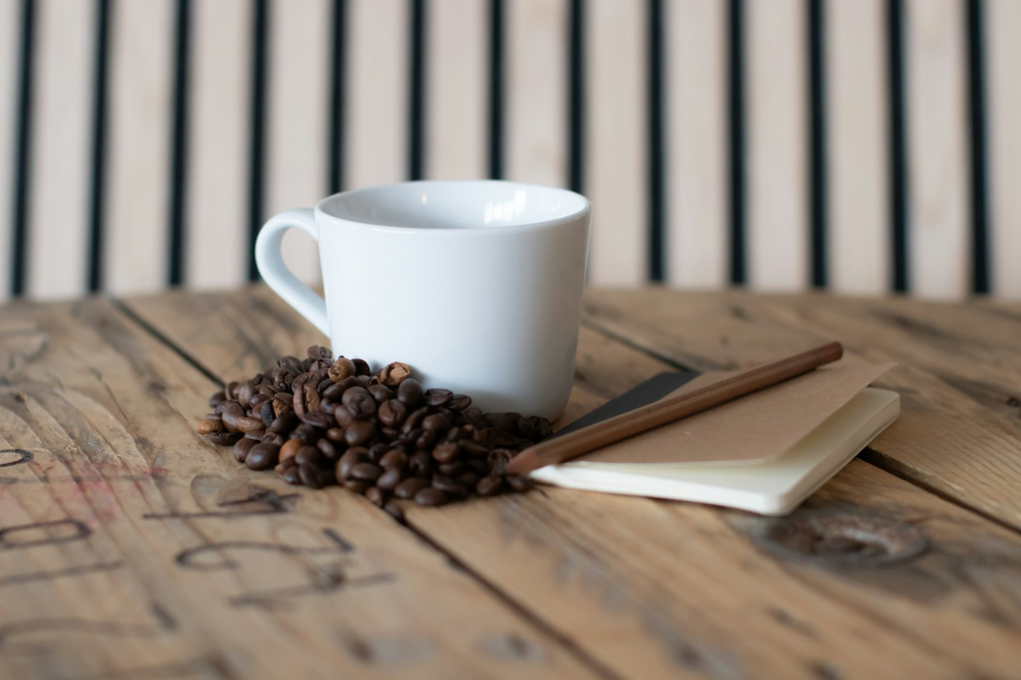 Tazza di caffè bianca e chicchi su un tavolo di legno rustico.